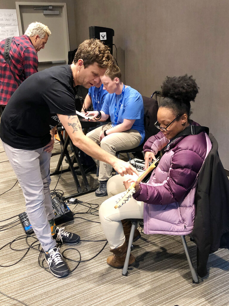Portrait of a Rock to Recovery participant with a guitar after a session